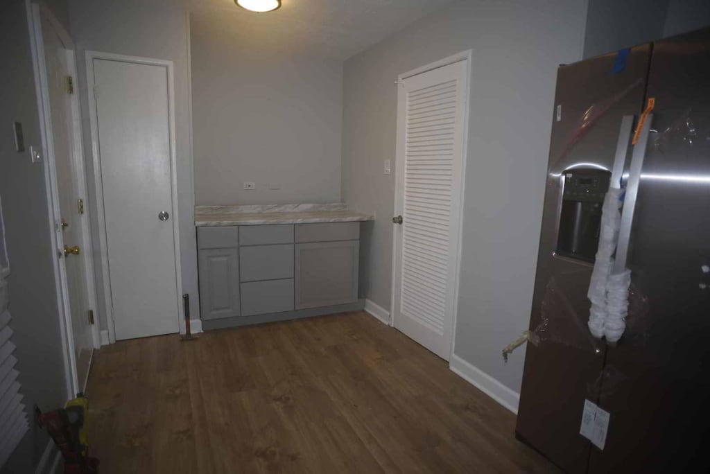 corridor featuring baseboards and wood finished floors