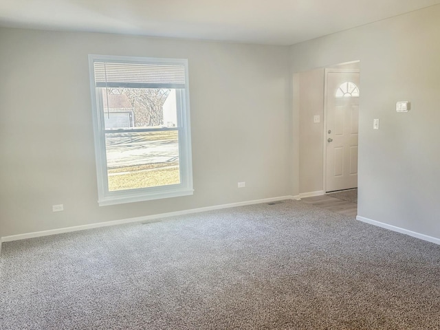 carpeted empty room featuring baseboards