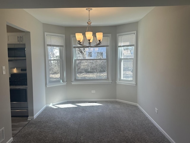 unfurnished dining area with a chandelier, carpet floors, visible vents, and baseboards