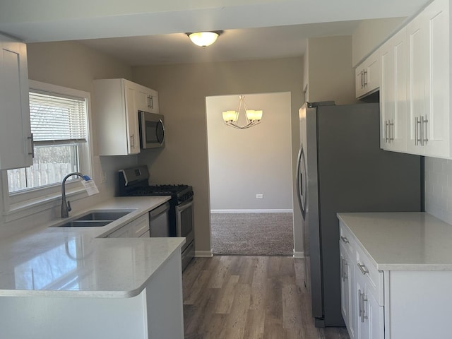 kitchen featuring white cabinets, dark wood-type flooring, stainless steel appliances, and a sink