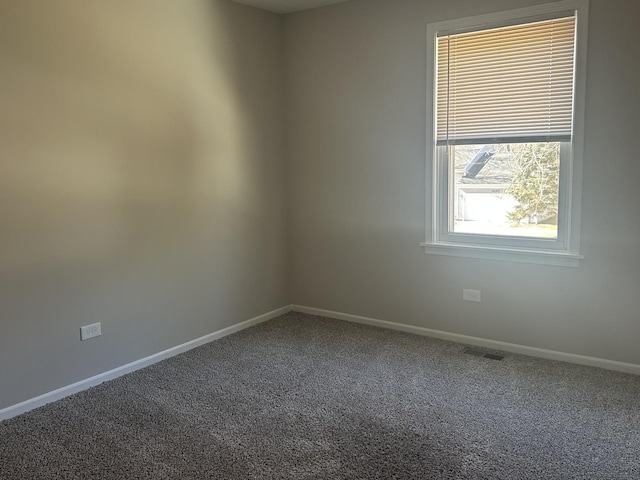 empty room featuring carpet flooring, visible vents, and baseboards