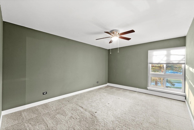 spare room featuring ceiling fan, carpet flooring, and baseboards