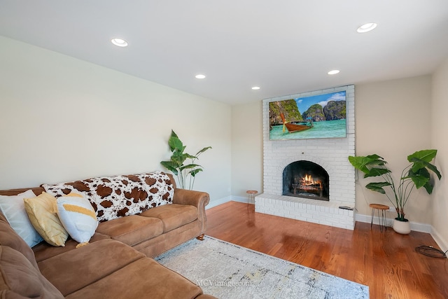 living room with recessed lighting, a fireplace, baseboards, and wood finished floors