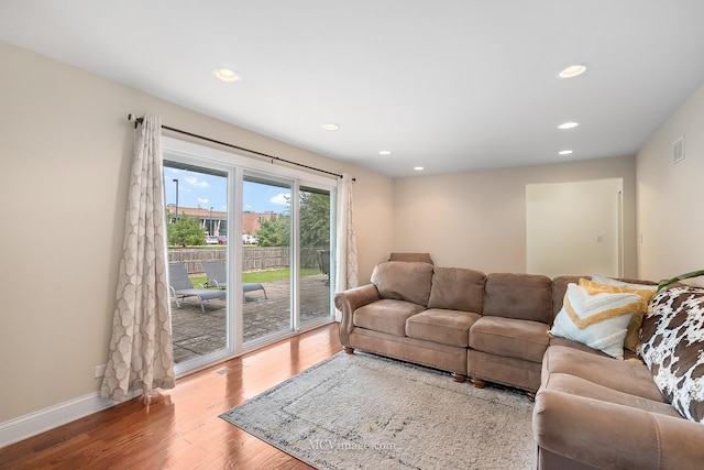 living area with baseboards, wood finished floors, visible vents, and recessed lighting