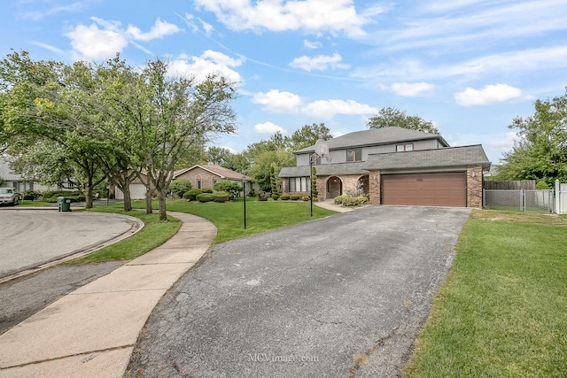 view of front facade featuring brick siding, a front yard, fence, a garage, and driveway