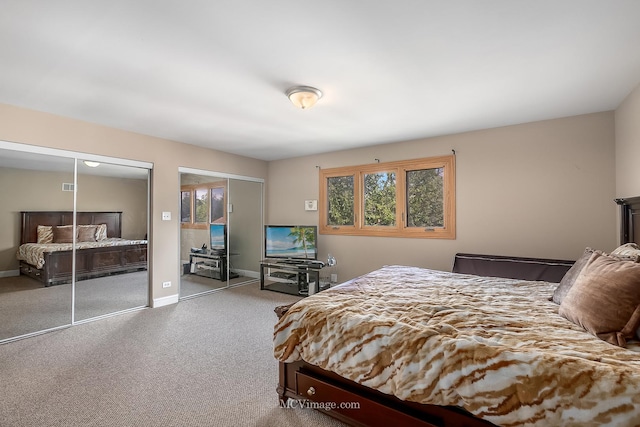 carpeted bedroom featuring baseboards and multiple closets