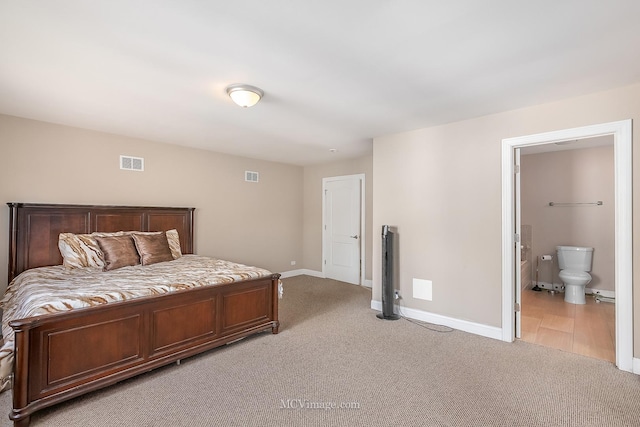 bedroom featuring baseboards, visible vents, ensuite bathroom, and light colored carpet