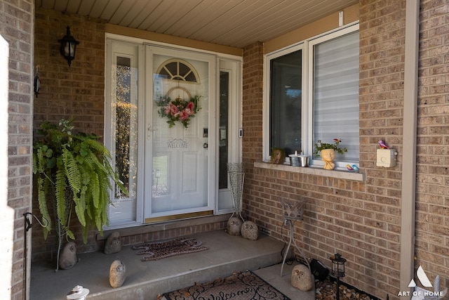 view of exterior entry with brick siding