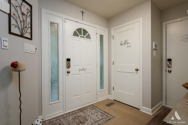 entryway with light wood finished floors, visible vents, and baseboards