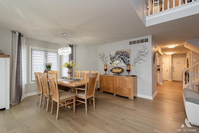 dining area with stairway, wood finished floors, visible vents, and baseboards