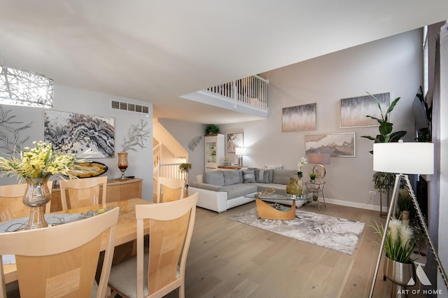 living area featuring baseboards, visible vents, and wood finished floors