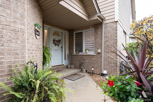 view of exterior entry with brick siding