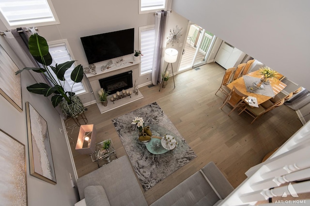 living room with visible vents, wood finished floors, and a high end fireplace