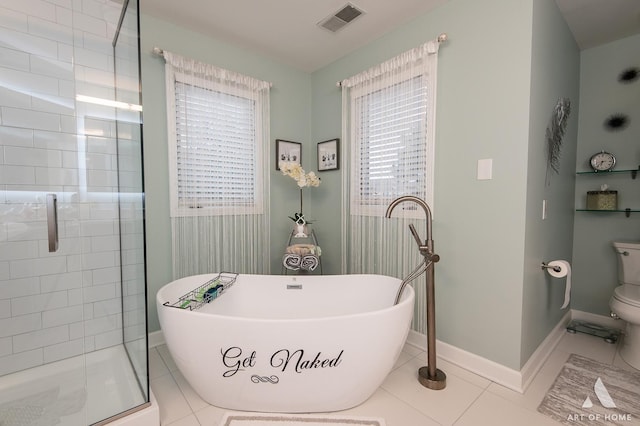 bathroom with visible vents, a freestanding bath, toilet, a stall shower, and baseboards