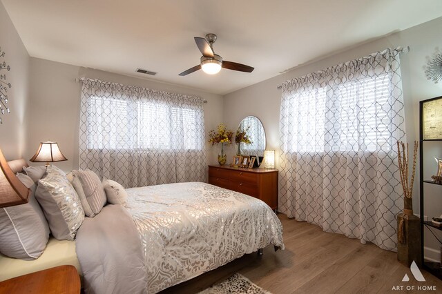 bedroom with visible vents, ceiling fan, and light wood finished floors