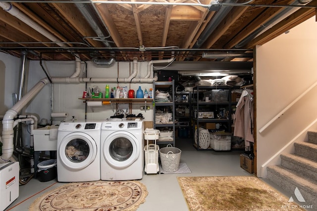 clothes washing area featuring laundry area, a sink, and washer and clothes dryer