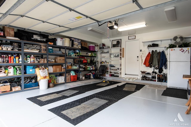 garage with a garage door opener and freestanding refrigerator