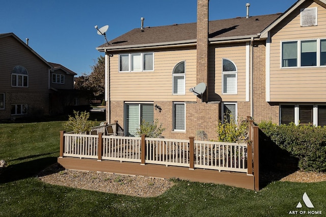 back of property with a yard, brick siding, a chimney, and roof with shingles