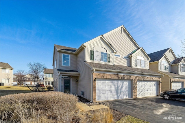 view of front of home with an attached garage, a residential view, driveway, and roof with shingles