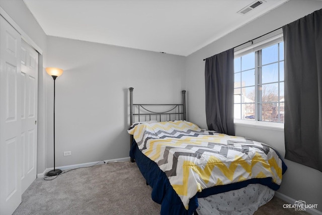 bedroom with a closet, baseboards, visible vents, and carpet floors