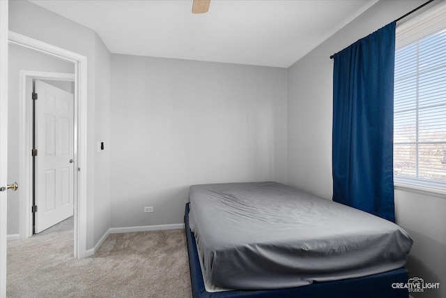 carpeted bedroom featuring baseboards and a ceiling fan