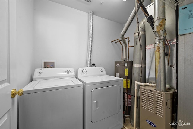 laundry room featuring water heater, laundry area, washer and dryer, and heating unit