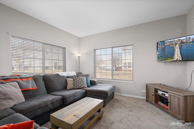 living area with baseboards and light carpet