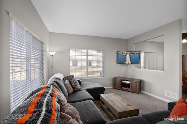 living area featuring visible vents, baseboards, and carpet