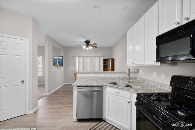 kitchen with a peninsula, white cabinets, black appliances, a ceiling fan, and a sink