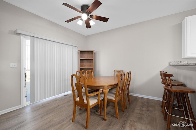 dining space with wood finished floors, baseboards, and ceiling fan