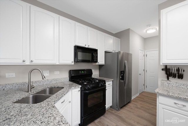 kitchen with white cabinets, black appliances, and a sink