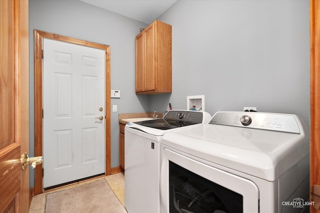 washroom featuring a sink, cabinet space, and washer and dryer