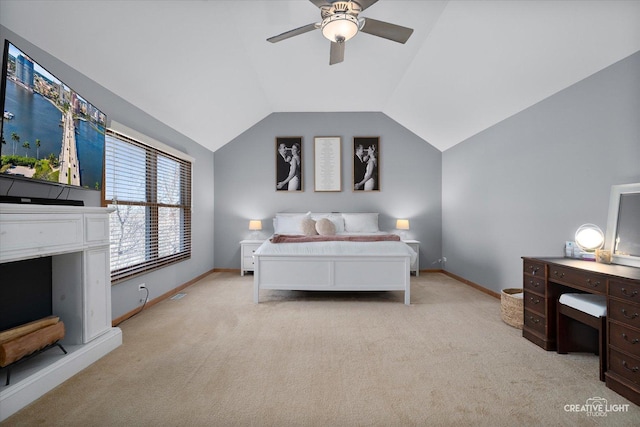 bedroom with a ceiling fan, light colored carpet, vaulted ceiling, and baseboards