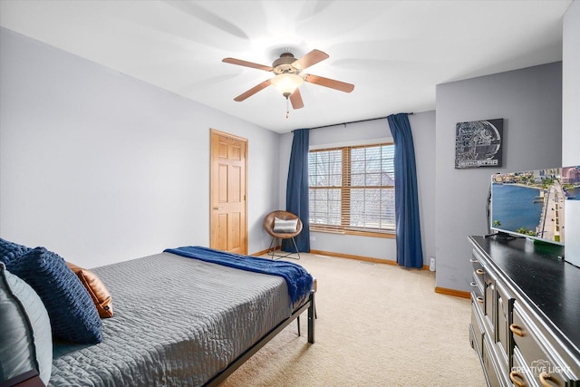 bedroom with light carpet, a ceiling fan, and baseboards