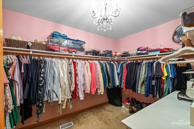 spacious closet featuring carpet, visible vents, and a notable chandelier