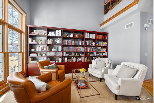 living area with a high ceiling and visible vents