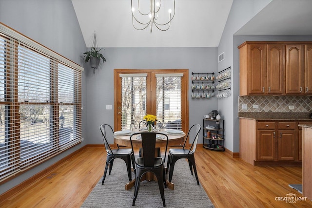 dining area with light wood finished floors, vaulted ceiling, and a wealth of natural light