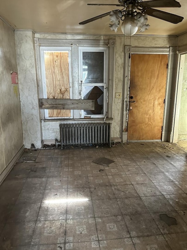 spare room featuring radiator heating unit and a ceiling fan