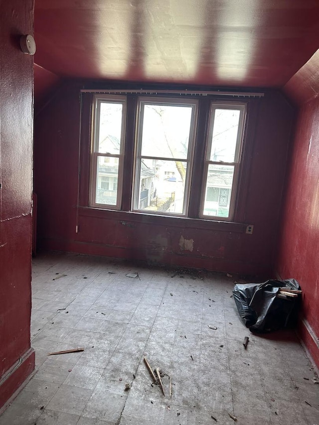 bonus room with vaulted ceiling and tile patterned floors