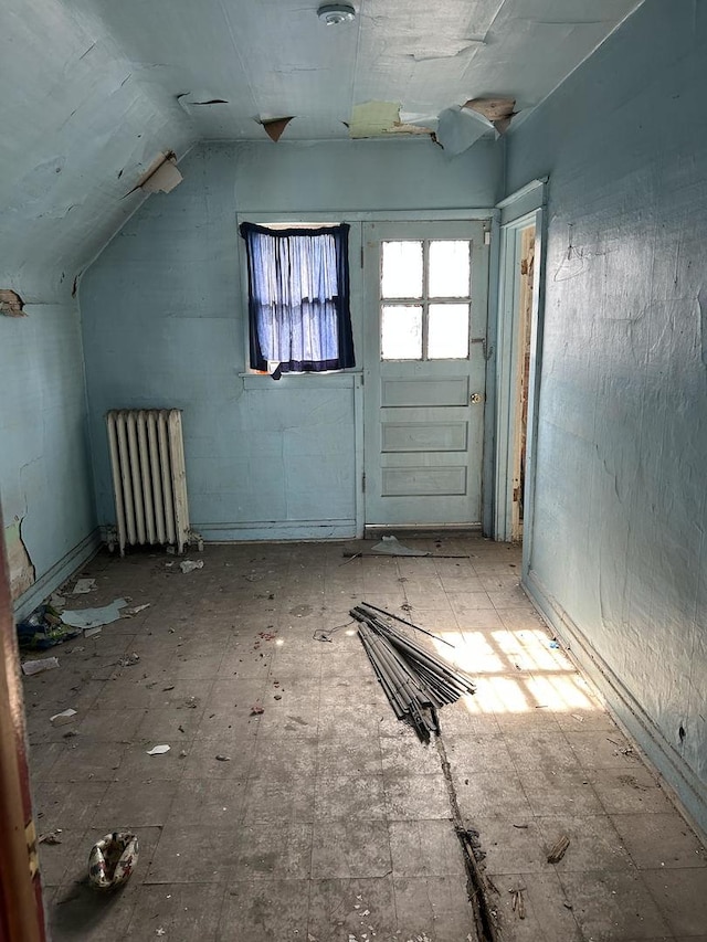 interior space with vaulted ceiling and radiator