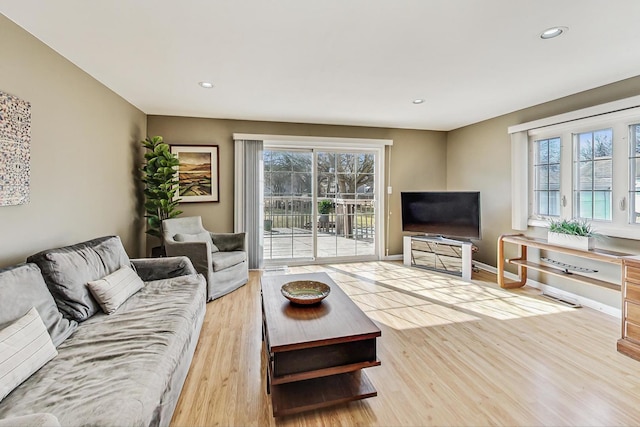 living room with baseboards, light wood-type flooring, and recessed lighting