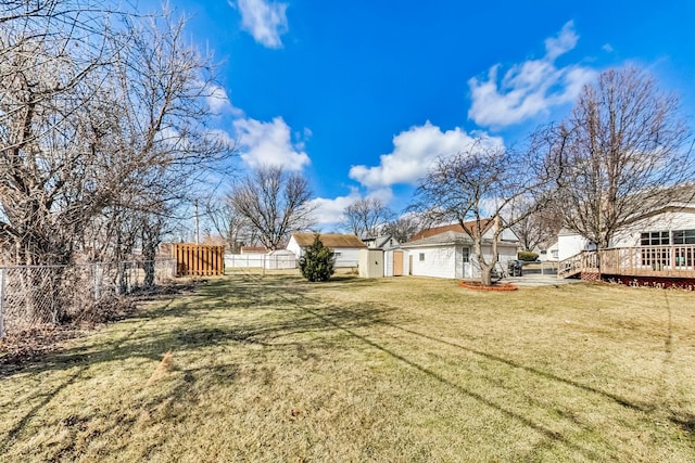 view of yard with a deck, an outbuilding, and fence