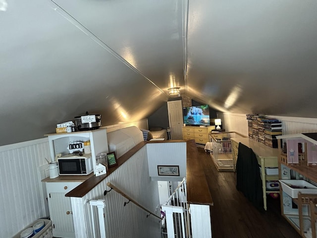 bonus room with lofted ceiling, wainscoting, and wood finished floors