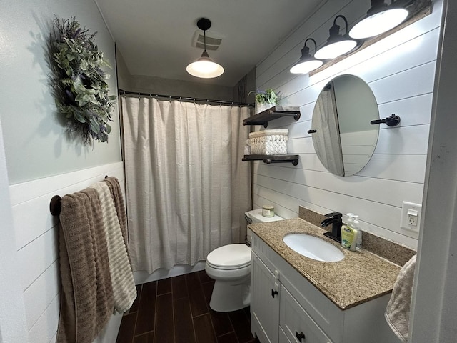 bathroom featuring toilet, vanity, visible vents, and wood tiled floor