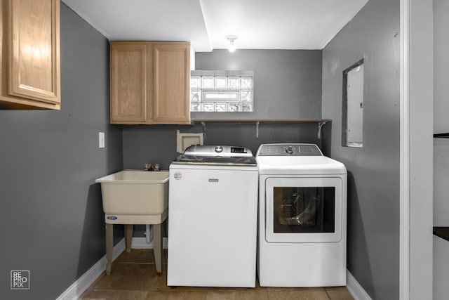 laundry room with cabinet space, baseboards, washing machine and clothes dryer, tile patterned flooring, and a sink