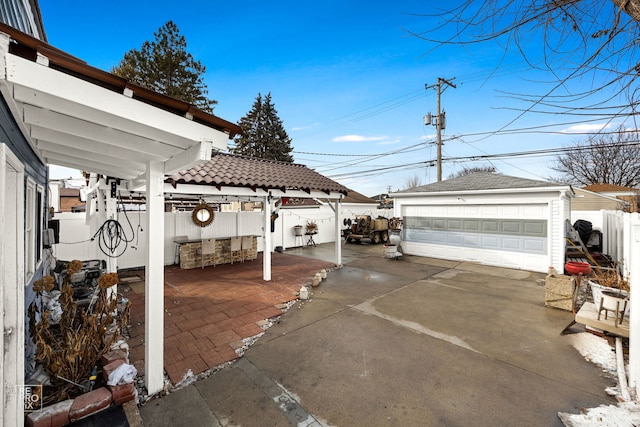 view of patio featuring an outdoor structure, a fenced backyard, and a detached garage