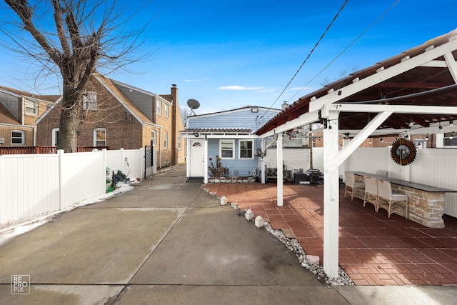 exterior space featuring a patio area, a fenced backyard, and outdoor dry bar