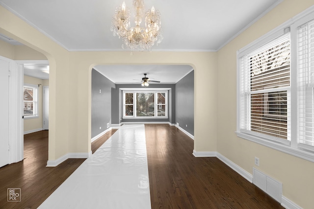 unfurnished dining area with arched walkways, plenty of natural light, wood finished floors, and visible vents