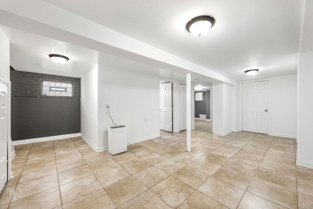 basement with light tile patterned flooring and baseboards