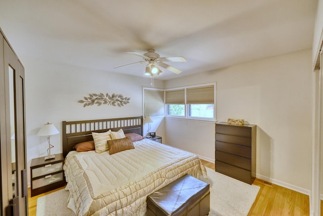 bedroom featuring light wood finished floors, baseboards, and a ceiling fan